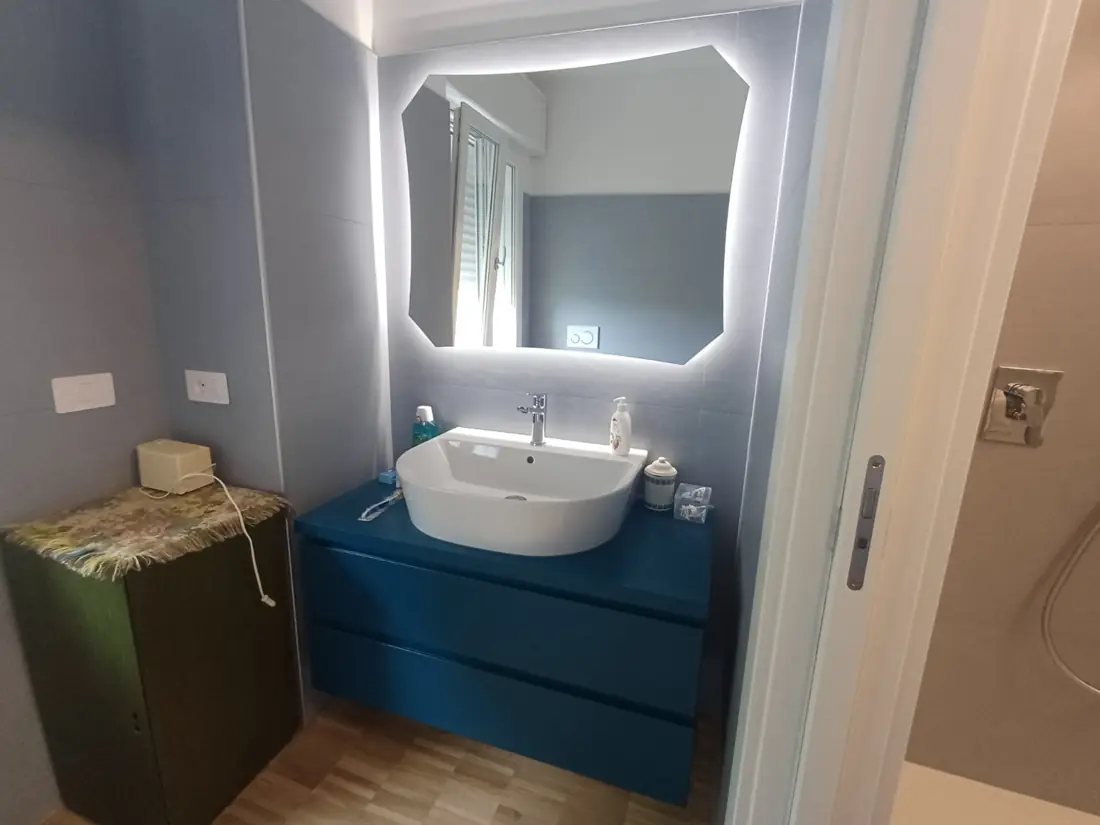 Specchio da bagno sagomato con LED perimetrale acceso